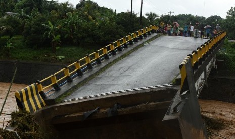 Warga menyaksikan Jembatan Manuju yang ambruk akibat diterjang air di Desa Moncongloe, Manuju, Kabupaten Gowa, Sulawesi Selatan, Rabu (23/1/2019).