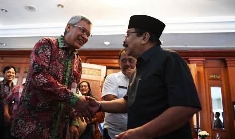 Gubernur Jawa Timur Soekarwo (kanan) berbincang bersama Kepala Bank Indonesia Jawa Timur Difi Ahmad Djohansyah (kiri) seusai pertemuan Tim Pengendalian Inflasi Daerah (TPID) di Surabaya, Jawa Timur, Rabu (23/1/2019).