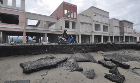 Pengendara melintasi bangunan ruko yang rusak akibat bencana gempa dan tsunami di Kawasan Wisata Pantai Teluk Palu di Palu, Sulawesi Tengah, Rabu (23/1/2019). 