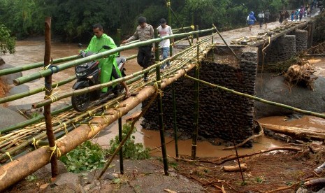 Warga melewati jembatan darurat sementara yang terbuat dari bambu di desa Pallatikang, Kabupaten Gowa, Sulawesi Selatan, Kamis (24/1/2019). 