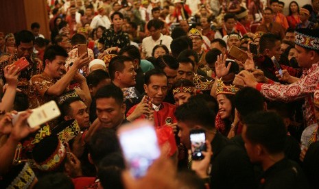 Capres nomor urut 01 Joko Widodo (tengah) berswafoto bersama Masyarakat adat Dayak usai hadiri silahturahmi nasional masyarakat Dayak di Jakarta, Sabtu (26/1/19).