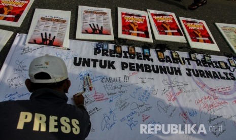 Jurnalis membentangkan spanduk dan poster untuk memberi dukungan dalam aksi damai 'Cabut Remisi Pembunuh Jurnalis' 