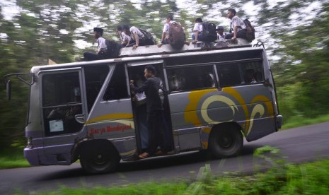 Sejumlah siswa duduk di atas bus yang melintas di jalan Solo-Purwodadi, Kedungombo, Sumberlawang, Sragen, Jawa Tengah, Senin(28/1/2019).