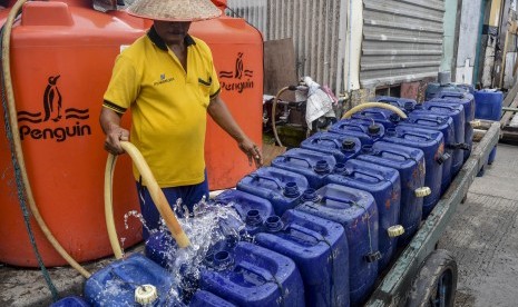 Serang pekerja mengisi air bersih ke dalam jerigen untuk dijual di Muara Angke, Jakarta, Senin (28/1/2019).