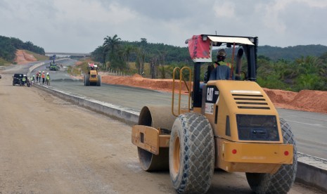 Sejumlah pekerja menyelesaikan pekerjaan pembangunan jalan tol Pekanbaru-Dumai Seksi 1 di Provinsi Riau, Rabu (30/1/2019).