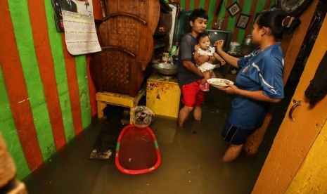 Warga beraktivitas di dalam rumahnya saat banjir mengggenangi kawasan Rawa Buaya di Jakarta Barat, Rabu (30/1). Rawa Buaya adalah salah satu contoh daerah di DKI Jakarta yang memiliki banyak cekungan.