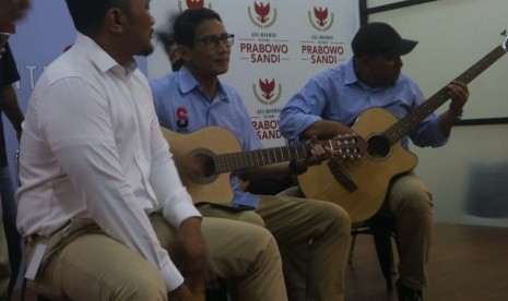 Calon wakil presiden (cawapres) nomor urut 02 Sandiaga Salahuddin Uno menyanyikan lagu Dewa 19 berjudul Hadapi Dengan Senyuman tribute to Ahmad Dhani di Media Center Prabowo-Sandi, Kebayoran Baru, Jakarta, Kamis 