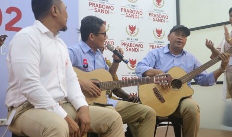 Calon wakil presiden (cawapres) nomor urut 02 Sandiaga Salahuddin Uno menyanyikan lagu Dewa 19 berjudul Hadapi Dengan Senyuman tribute to Ahmad Dhani di Media Center Prabowo-Sandi, Kebayoran Baru, Jakarta, Kamis. 