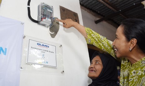 Menteri Badan Usaha Milik Negara (BUMN) Rini Soemarno (kanan) menyalakan lampu listrik saat meninjau rumah warga penerima bantuan sambungan listrik gratis untuk masyarakat tidak mampu melalui Program BUMN Hadir Untuk Negeri di Magetan, Jawa Timur, Jumat (1/2/2019).