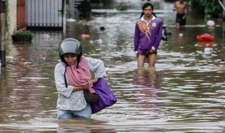 Warga melintasi banjir. (Ilustrasi)