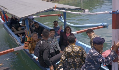 Menteri Kelautan dan Perikanan Susi Pudjiastuti (kanan) didampingi Bupati Trenggalek Emil Elestianto Dardak (tengah) menggunakan sarana transportasi kapal nelayan di Pelabuhan Perikanan Nusantara Prigi Trenggalek, Jawa Timur, Selasa (5/2/2019).