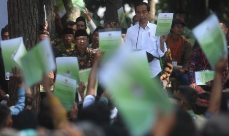 Presiden Joko Widodo menunjukkan Surat Keputusan tentang Pengelolaan Hutan Sosial saat berpidato di Wana Wisata Pokland Haurwangi, Cianjur, Jumat (8/2/2019).