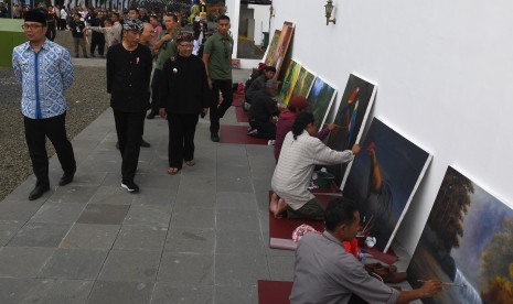 Presiden Joko Widodo (tengah) berjalan didampingi Gubernur Jawa Barat Ridwan Kamil (kiri) dan Plt Bupati Cianjur Herman Suherman (kanan) saat meninjau Alun-alun kota Cianjur, Jawa barat, Jumat (8/2/2019).