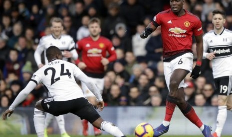 Striker Manchester United, Paul Pogba (kanan), diadang  Fulham Michael Seri pada  laga Liga Inggris di stadion Craven Cottage, London, Sabtu.