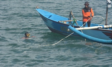 Tim SAR gabungan melakukan pencarian korban terseret ombak dengan menyelam menggunakan alat bantu pernafasan kompresor di Pantai Payangan, Ambulu, Jember, Jawa Timur, Senin (11/2/2019).