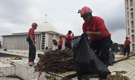 Petugas Dinas Pemadam Kebakaran DKI Jakarta membersihkan atap masjid pada kegiatan Grebek Bersih Masjid Istiqlal di Masjid Istiqlal, Jakarta, Selasa (12/2/2019).