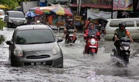 Sejumlah pengendara kendaraan melewati banjir yang menggenangi Jalan M. Yatim Kota Pekanbaru, Riau (ilustrasi).