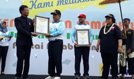 Bupati Indramayu Supendi (topi hitam) menerima penghargaan MURI yang diserahkan oleh Senior Manager MURI Yusuf Ngadri dan disaksikan Menteri Lingkungan Hidup dan Kehutanan Republik Indonesia Siti Nurbaya Bakar pada acara Coastal Clean Up yang digeIar di Pantai Kejawanan Cirebon, Jumat (15/2). 