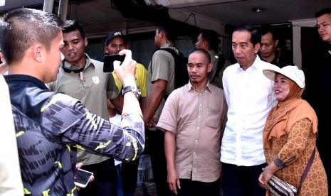 Calon presiden nomor urut 01, Jokowi, berfoto bersama warga usai menyantap hidangan makan siang bersama keluarganya di Kelapa Gading, Jakarta Utara, Ahad (17/2) siang. 