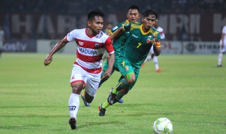 Pesepak bola Madura United (MU) Andik Vermansyah (kiri) melewati pesepak bola Sriwijaya FC Hafit Ibrahim (kanan) dalam Laga 16 Besar Leg pertama Piala Indonesia di Stadion Gelora Pamelingan (SGRP) Pamekasan, Jawa Timur, Ahad (17/2/2019).