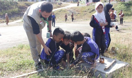 Anak-anak sekolah dasar di Aceh Besar bersama LKC Dompet Dhuafa membersihkan tempat yang bisa dijadikan sarang nyamuk penyebab DBD. 