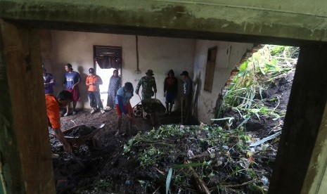 Warga bergotong royong membersihkan rumah yang terkena tanah longsor di Desa Pamongan, Kediri, Jawa Timur, Rabu (20/2/2019).