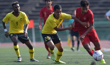 Timnas U-22 Indonesia lawan Malaysia: Pemain Timnas U-22 Indonesia Osvaldo Haay (kanan) berebut bola dengan pemain Malaysia Muhammad Nazirul Afif Ibrahim (tengah) dalam pertandingan Grup B Piala AFF U-22 di Stadion Nasional Olimpiade Phnom Penh, Kamboja, Rabu (20/2/2019).