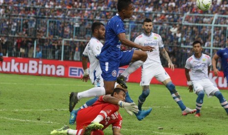 Arema Gagal Lolos: Pesepak bola Arema FC, Ridwan Tawainela (kiri) berebut bola dengan penjaga gawang Persib Bandung, M Natsir (bawah) dalam pertandingan babak 16 Besar Leg Kedua Piala Indonesia di Stadion Kanjuruhan, Malang, Jawa Timur, Jumat (22/2/2019).