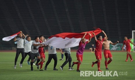 Pemain dan ofisial Timnas U-22 membawa Bendera Merah Putih setelah berhasil memenangi babak Final Piala AFF U-22 di Stadion Nasional Olimpiade Phnom Penh, Kamboja, Selasa (26/2/2019).