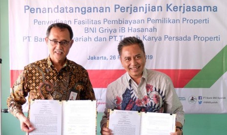 SEVP Bisnis Ritel dan Jaringan BNI Syariah, Iwan Abdi (kiri) dan Direktur Timah Properti, Eko Budisantoso (kanan) bungkus kerja sama fasilitas kepemilikan rumah untuk proyek perumahan dari Timah Properti, yaitu Familia Urban di Bekasi dan Payon Ponca di Tangerang Selatan (26/2). 