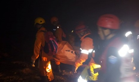 Sejumlah anggota tim SAR mengevakuasi salah seorang korban tambang emas yang longsor di Desa Bakan, Kecamatan Lolayan, Kabupaten Bolaang Mongondow, Sulawesi Utara, Selasa (26/2/2019) malam.