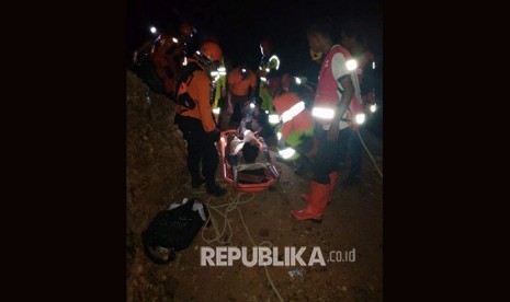 Sejumlah anggota tim SAR mengevakuasi salah seorang korban tambang emas yang longsor di Desa Bakan, Kecamatan Lolayan, Kabupaten Bolaang Mongondow, Sulawesi Utara, Selasa (26/2/2019) malam. 