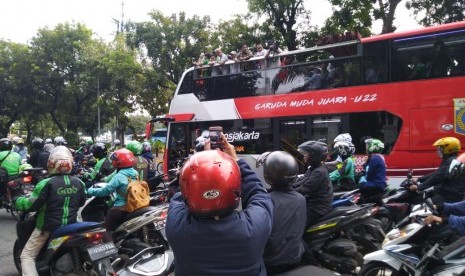 Pekerja dan pengguna jalan di jalan Thamrin menyaksikan pawai kemenangan Timnas sepakbola Indonesia U-22, Kamis (28/2). 