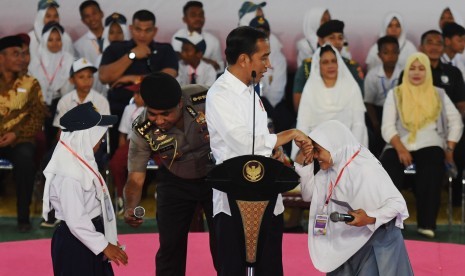 Jokowi Penyaluran KIP: Presiden Joko Widodo (kedua kanan) berjabat tangan dengan siswa saat penyerahan Kartu Indonesia Pintar (KIP) di Gorontalo, Jumat (1/3/2019).