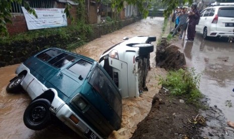 TPT Jebol: Dua unit mobil yang terparkir di pinggir sungai Sasak Dua, Ciapus,  Kecamatan Banjaran, Kabupaten Bandung terguling masuk ke dalam aliran air  tersebut sekitar pukul 16.38 Wib, Jumat (1/3).