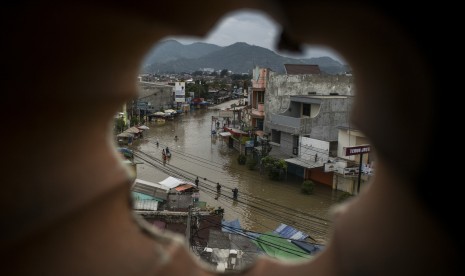 Warga melintasi banjir di Jalan Raya Dayeuhkolot, Kabupaten Bandung, Jawa Barat, Kamis (7/3/2019).