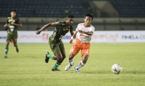 Pesepak bola Perseru Serui M Irvan Febrianto (kanan) dan pesepak bola Tira Persikabo Osas Marvellous Ikpefua (kiri) mengejar bola saat pertandingan Grup A Piala Presiden di Stadion Si Jalak Harupat, Kabupaten Bandung, Jawa Barat, Kamis (7/3/2019).