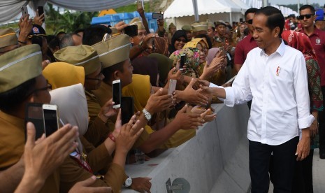 Presiden Joko Widodo menyalami aparatur sipil negara (ASN) sebelum meresmikan tol Trans Sumatera ruas Bakauheni-Terbanggi Besar di Gerbang Tol Natar, Lampung Selatan, Lampung, Jumat (8/3/2019).