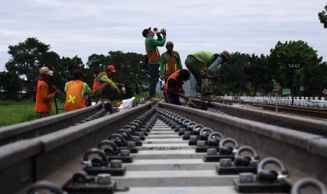 Pekerja memasang rel proyek jalur ganda rute Jombang-Madiun yang melintas di Desa Pandanwangi, Kecamatan Diwek, Kabupaten Jombang, Jawa Timur.