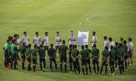 Pelatih timnas senior Indonesia Simon McMenemy (tengah) menyampaikan arahan kepada para pesepak bola timnas senior Indonesia dalam sesi latihan di Stadion Madya, Kompleks Gelora Bung Karno, Senayan, Jakarta, Jumat (8/3/2019).