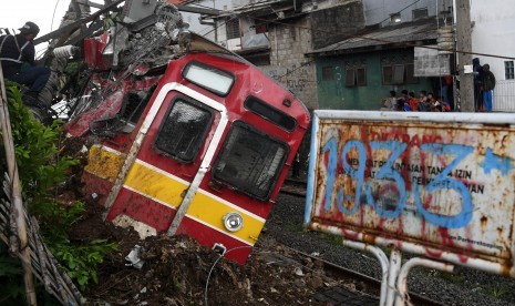 Petugas melakukan proses evakuasi KRL Commuter Line 1722 yang anjlok di pintu perlintasan Kebon Pedes, Tanah Sareal, Kota Bogor, Jawa Barat, Ahad (10/3/2019). 