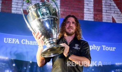 Pesepak bola legenda FC Barcelona Carles Puyol mengangkat trofi Liga Champion saat mengikuti UEFA Champions League Thropy Tour di Jakarta, Senin (11/3/2019). 