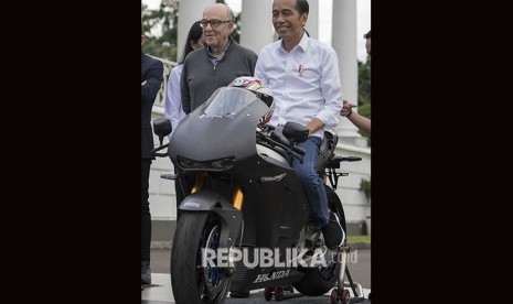 Presiden Joko Widodo (kanan) didampingi CEO Dorna Carmelo Ezpeleta (kiri) mencoba motor balap di Istana Bogor, Jawa Barat, Senin (11/3/2019).