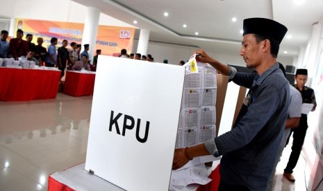 Sejumlah penyelenggara Pemilu 2019 melakukan pencoblosan kertas suara di bilik suara saat simulasi pemungutan dan perhitungan suara pemilihan umum 2019 di Sumenep, Jawa Timur, Sabtu (16/3/2019).