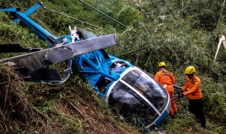 Petugas Basarnas memeriksa helikopter B-105 PK EAH milik PT Air Transport Service yang jatuh di Desa Jayaratu, Kabupaten Tasikmalaya, Jawa Barat, Sabtu (16/3/2019). 