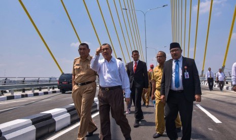 Gubernur Riau Syamsuar (tengah) melakukan pengecekan akhir di Jembatan Siak IV pada hari pertama pengoperasian jembatan itu di Kota Pekanbaru, Riau, Senin (18/3/2019). 