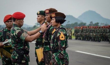 Danjen Kopassus Mayjen I Nyoman Cantiasa (kedua kiri) menyematkan lencana.