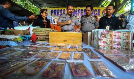 Polisi menunjukkan barang bukti uang palsu hasil sitaan saat jumpa pers di Polsek Godean, Sleman, DI Yogyakarta, Selasa (19/3/2019).