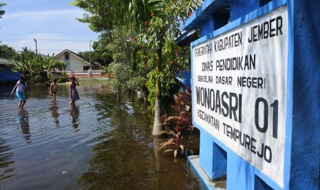 Siswa melintasi banjir di halaman SDN Wonoasri 01, Tempurejo, Jember, Jawa Timur. (ilustrasi)