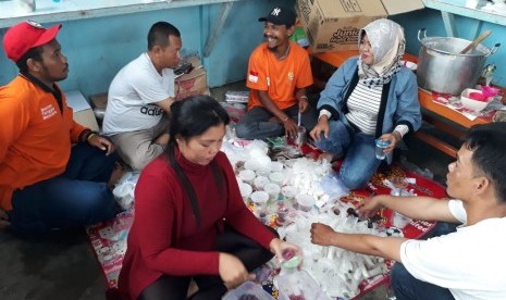 Relawan Baznas dan Rina Yulyana menyiapkan sarapan pagi bubur sumsum untuk para warga yang terdampak bencana banjir bandang di Sentani, Jayapura, Papua, Kamis (21/3). 